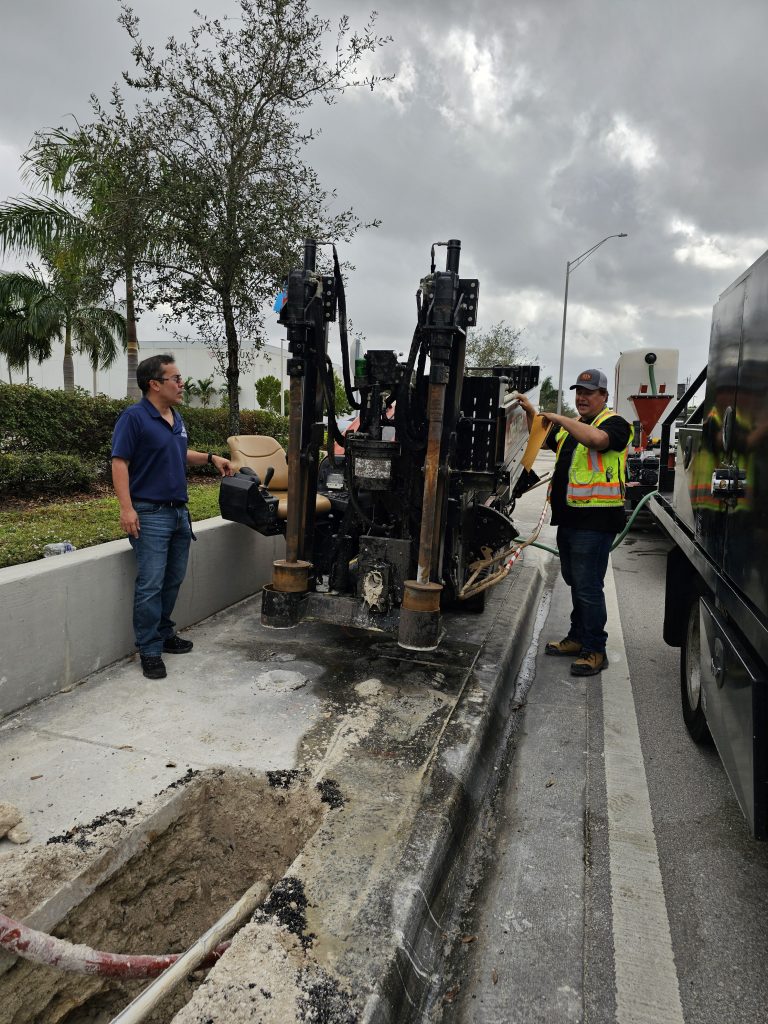 Crew operating underground utility drilling equipment on a Palm Beach County project site