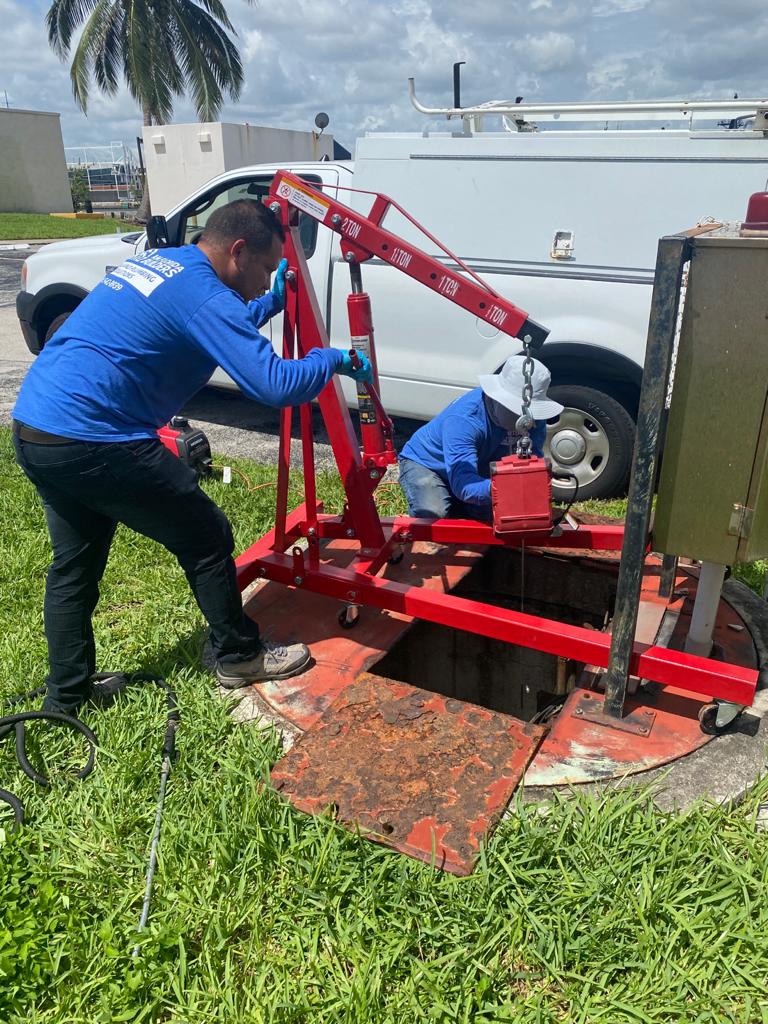 Utility crew accessing an underground utility vault during a Broward County project