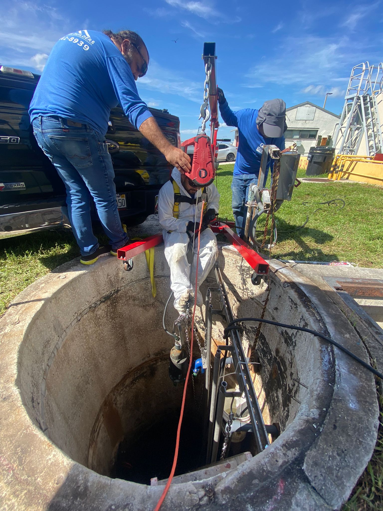 Utility crew working inside a concrete utility structure during underground infrastructure installation in Parkland, Florida