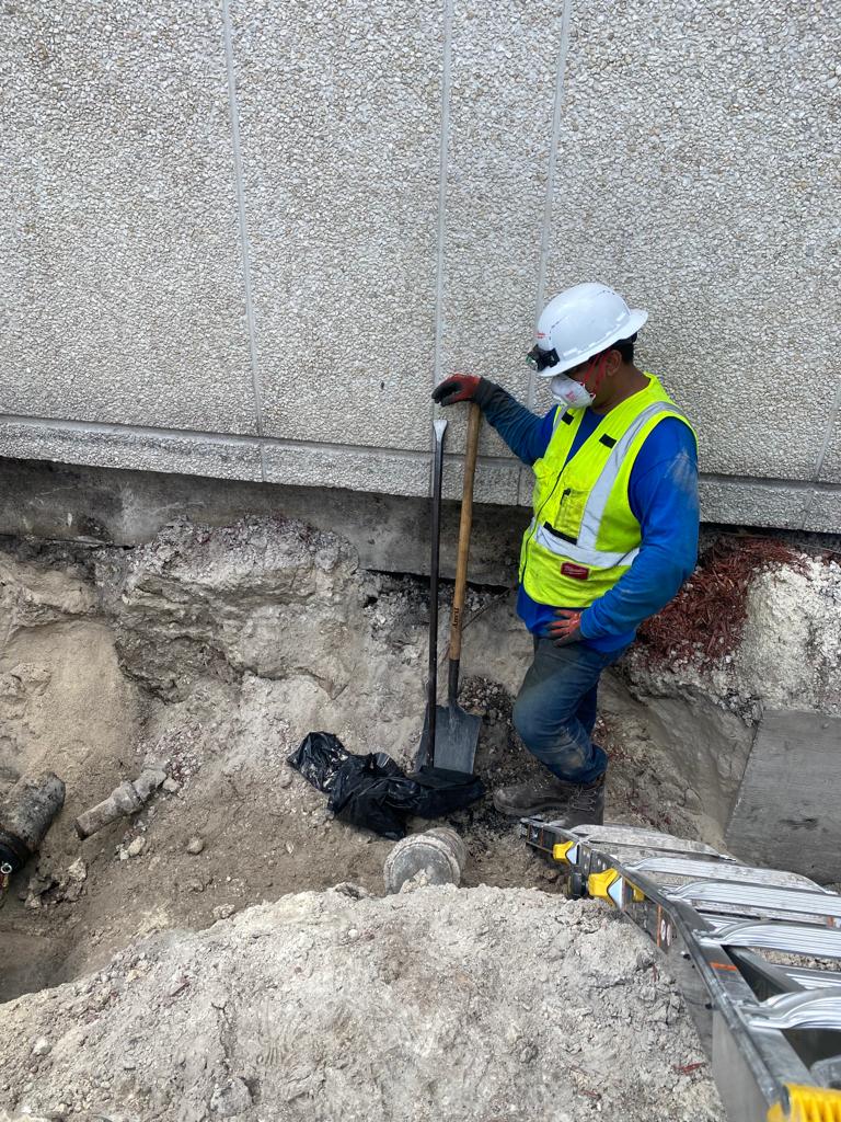 Utility worker inspecting underground infrastructure during excavation in Davie, Florida