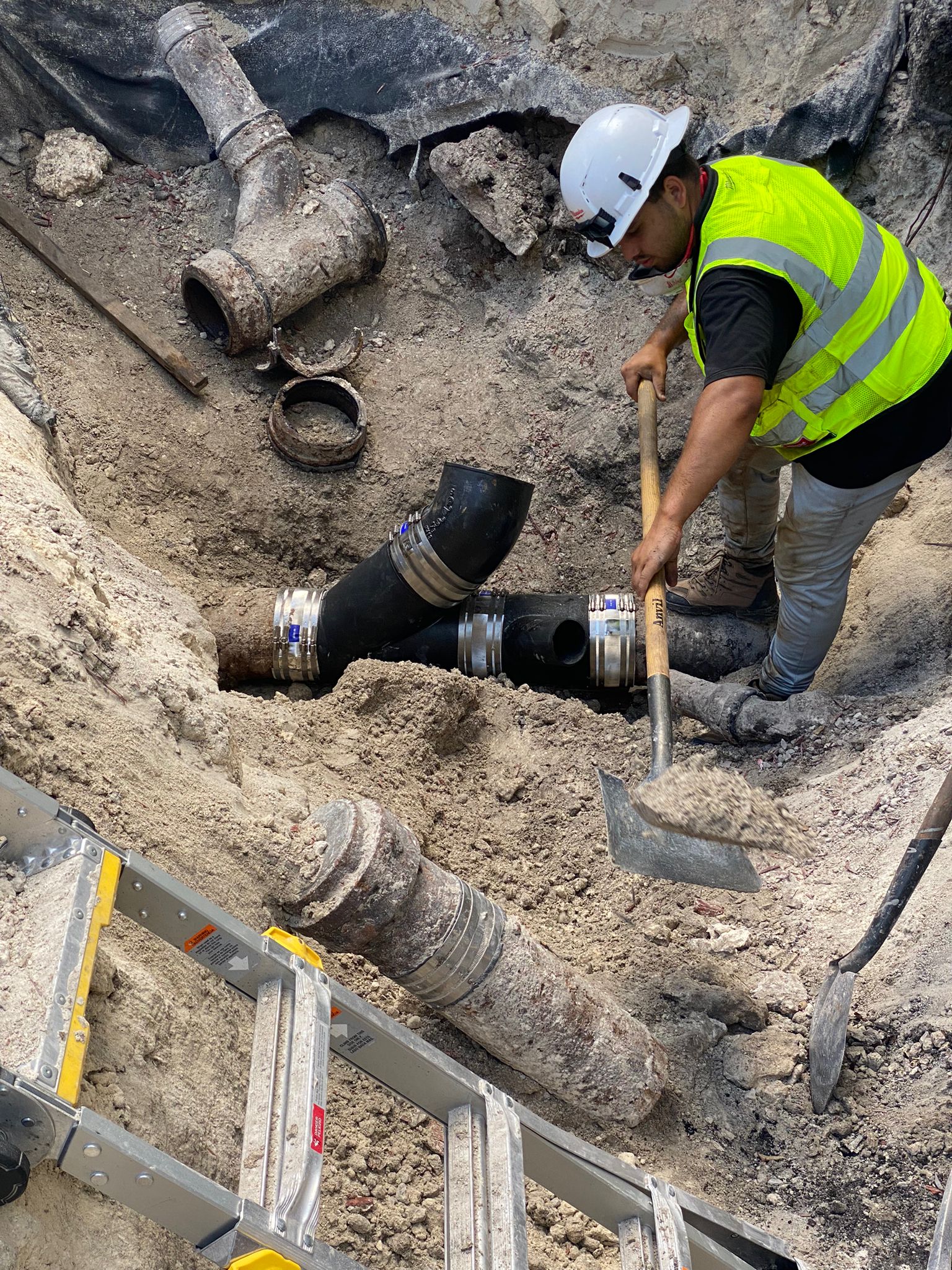 Utility crew working on underground pipes during excavation in Southwest Ranches, Florida