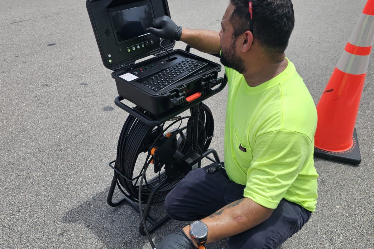 Technician performing sewer camera inspection using specialized underground utility inspection equipment